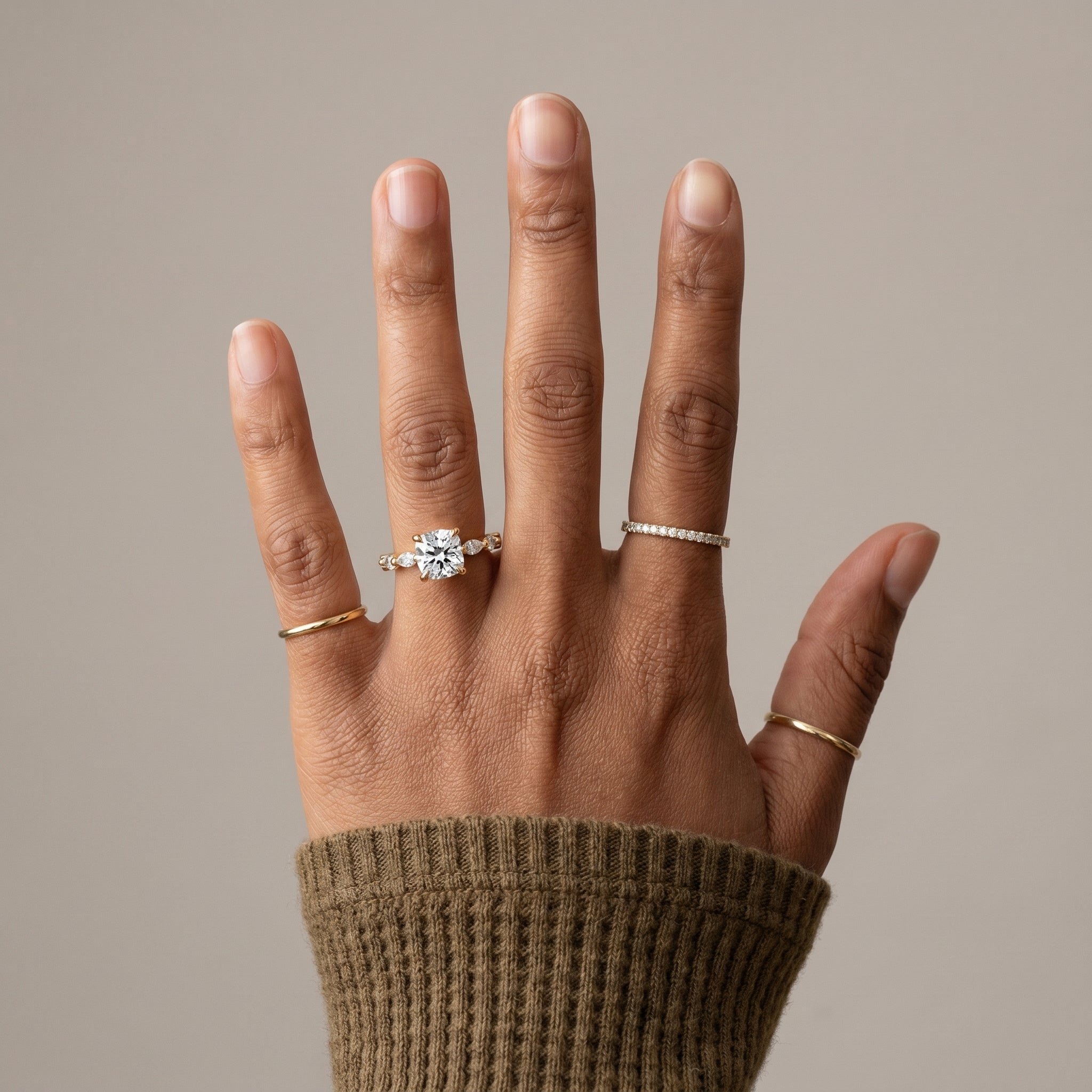 Cushion cut moissanite ring worn on hand with hidden halo and yellow gold finish