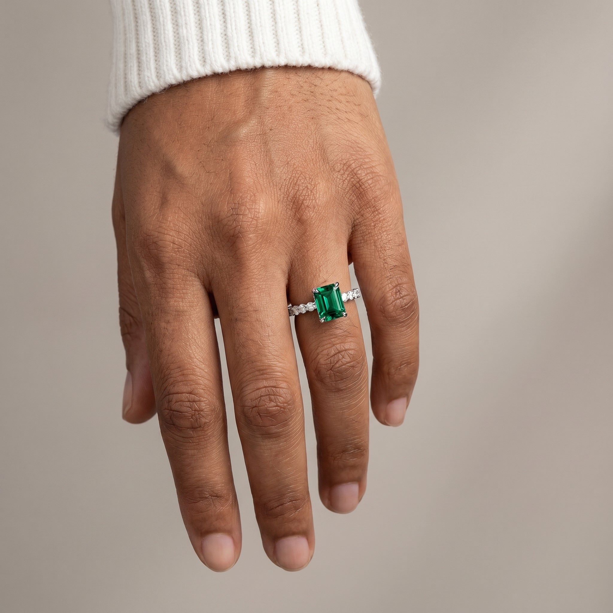 Green emerald cut moissanite engagement ring in sterling silver natural light
