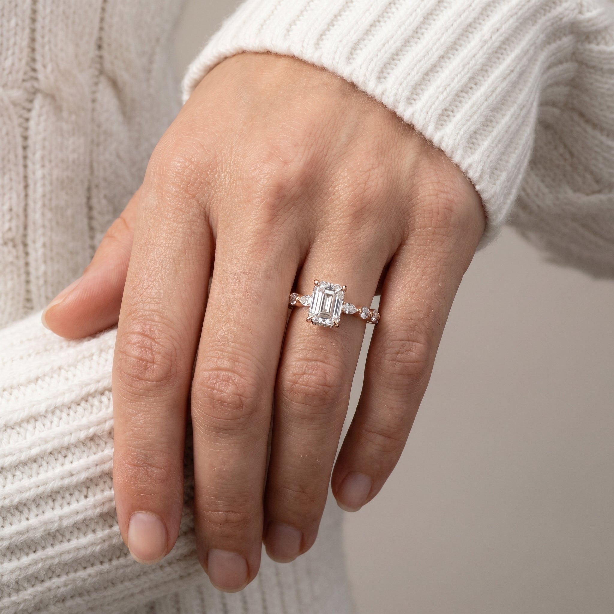 Emerald cut moissanite engagement ring in natural light with yellow gold band
