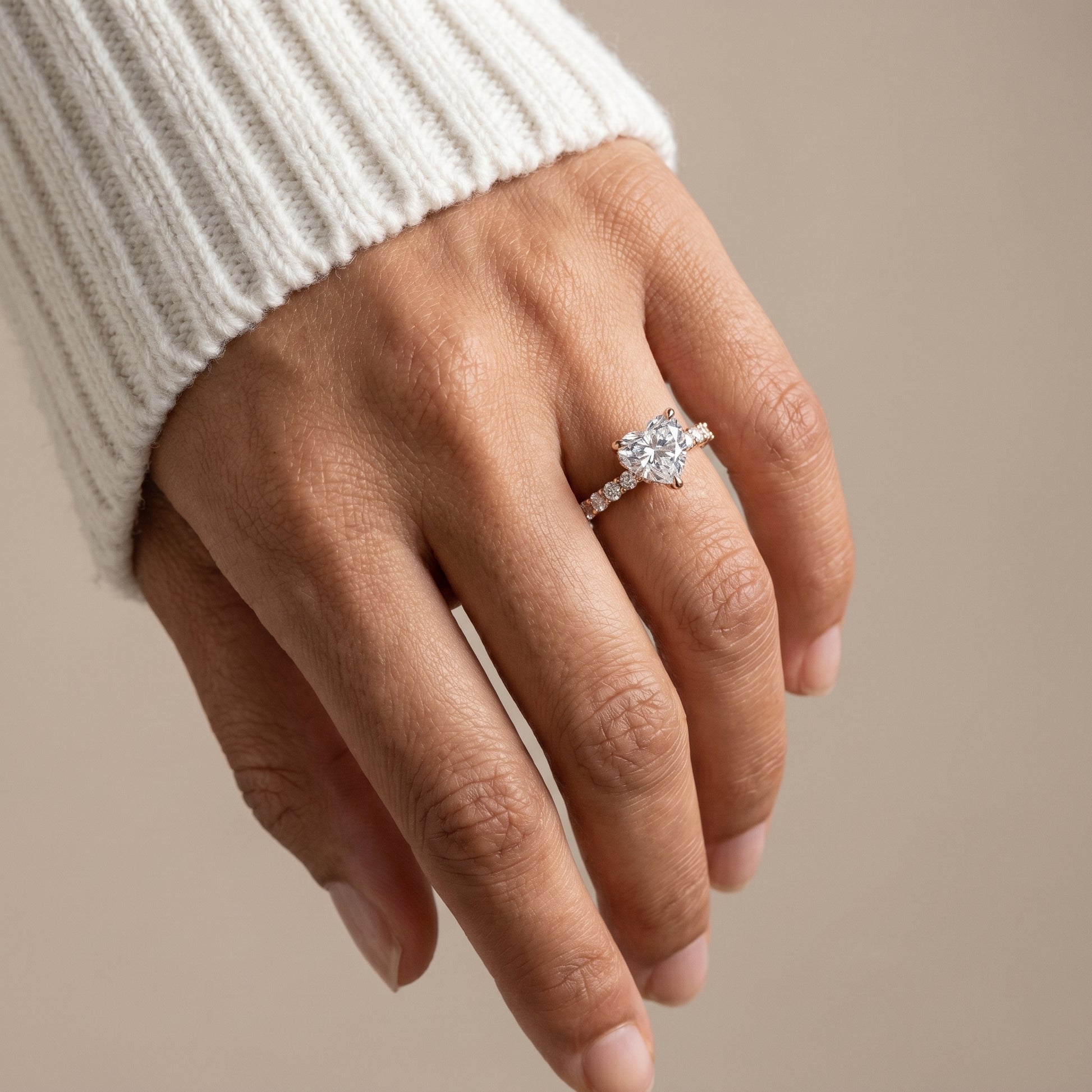 Heart shaped moissanite engagement ring in sterling silver with pavé band in natural light