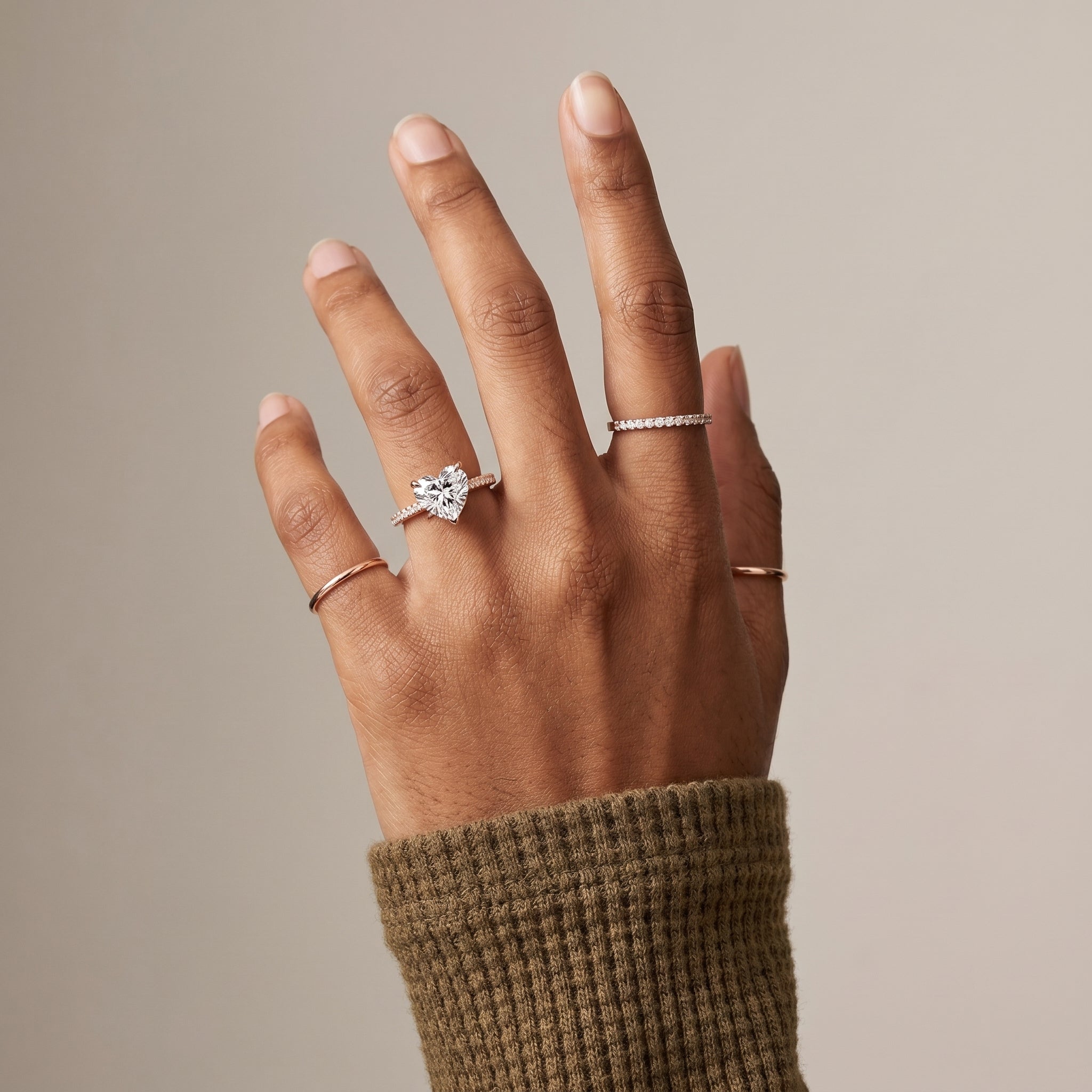 Heart cut moissanite ring worn on hand with pavé band in 925 sterling silver
