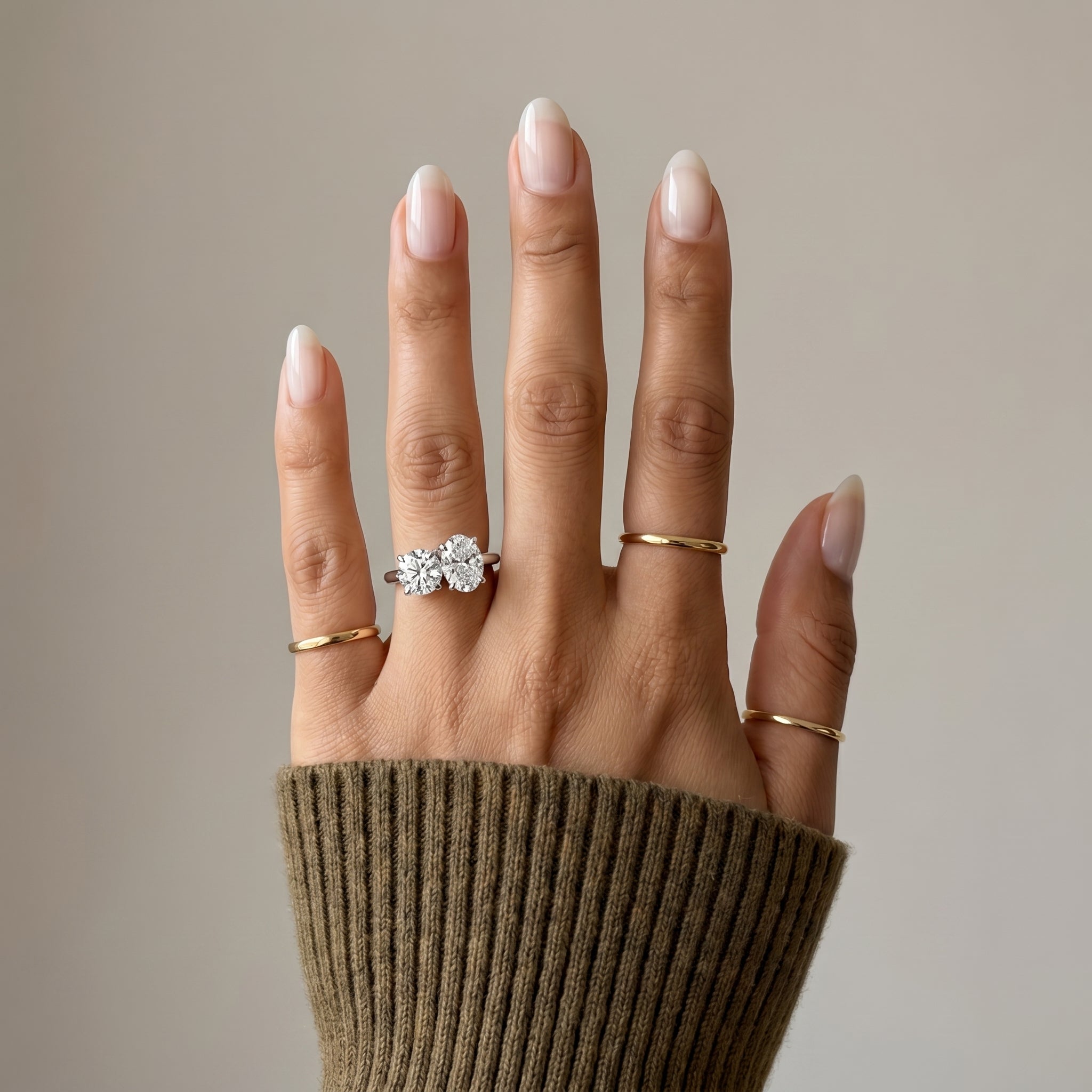 Side view of oval and round moissanite Toi et Moi ring gold finish