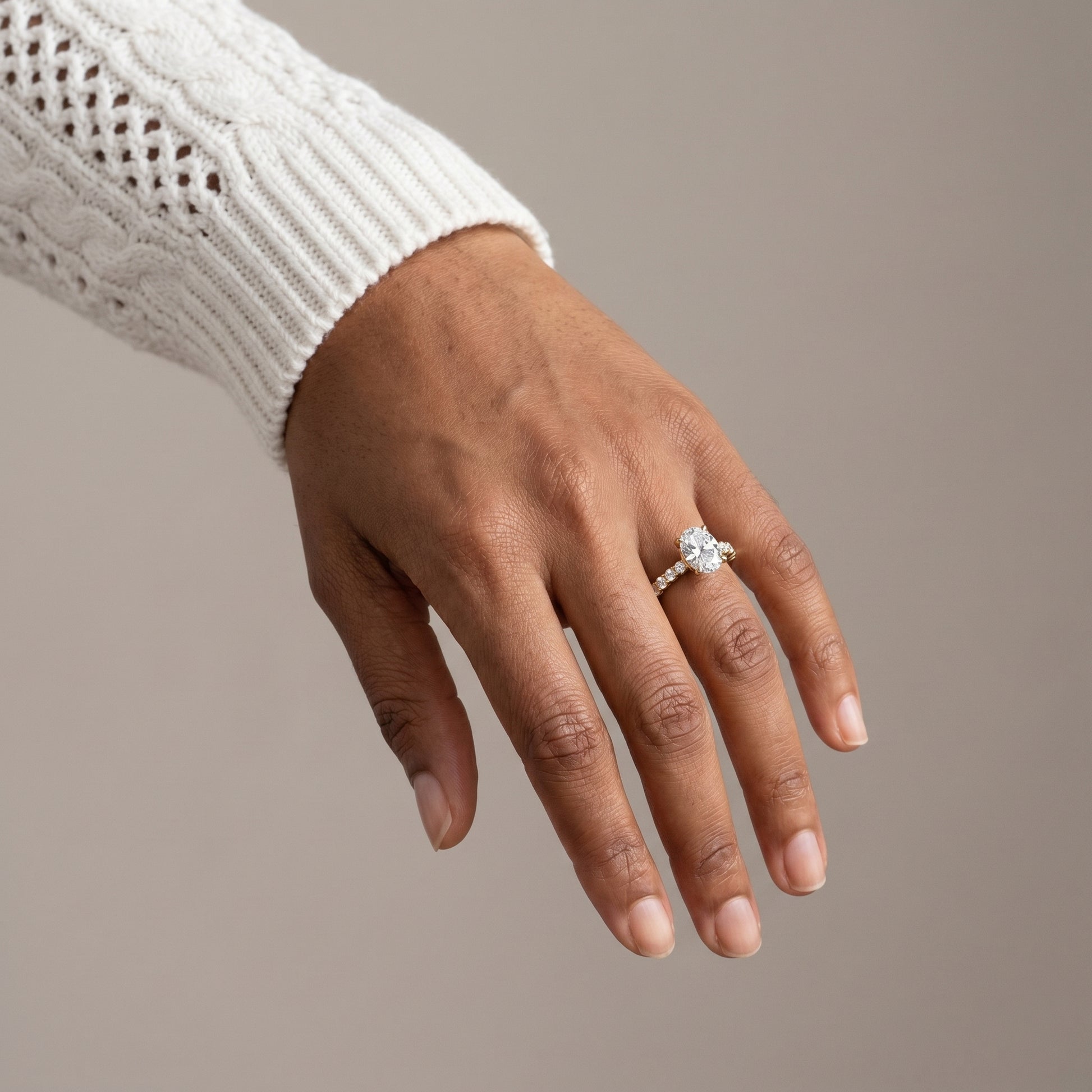 Oval moissanite engagement ring in sterling silver with pavé band in natural light
