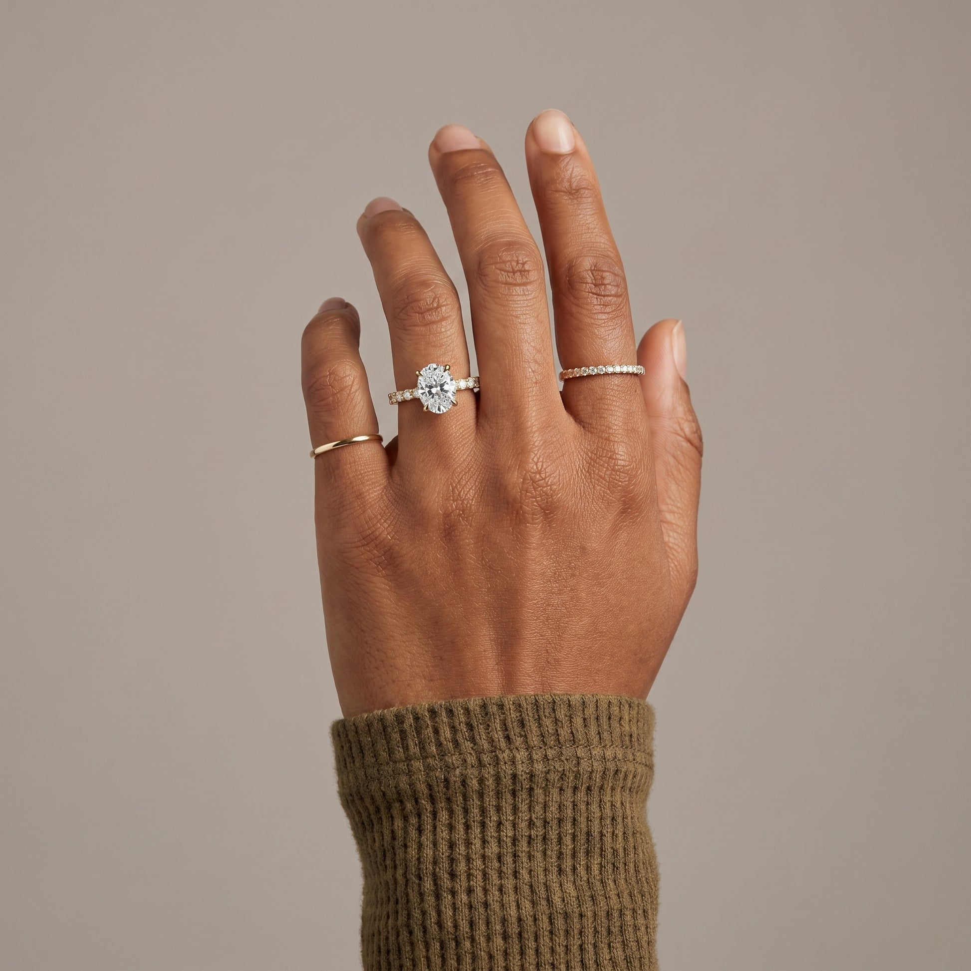 Oval cut moissanite ring worn on hand with pavé band in 925 sterling silver
