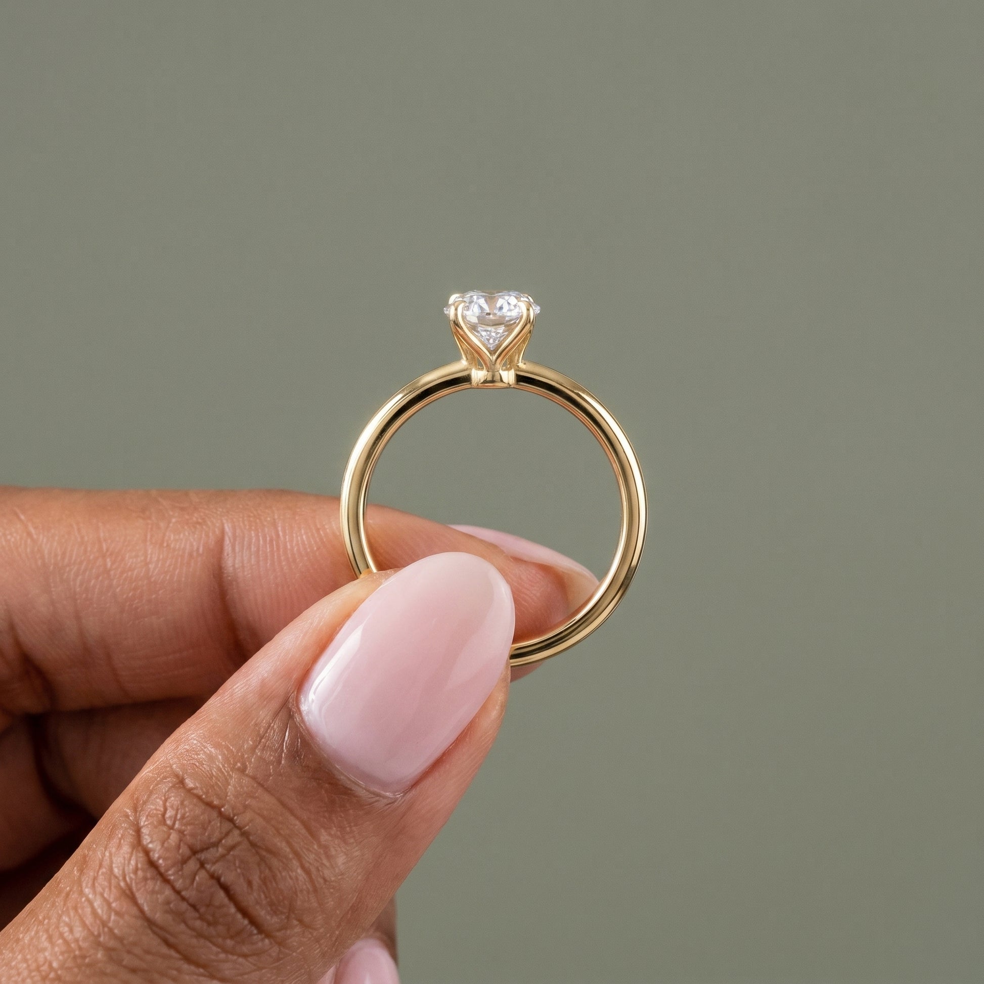 Oval moissanite engagement ring worn on hand elegant lifestyle yellow gold jewelry