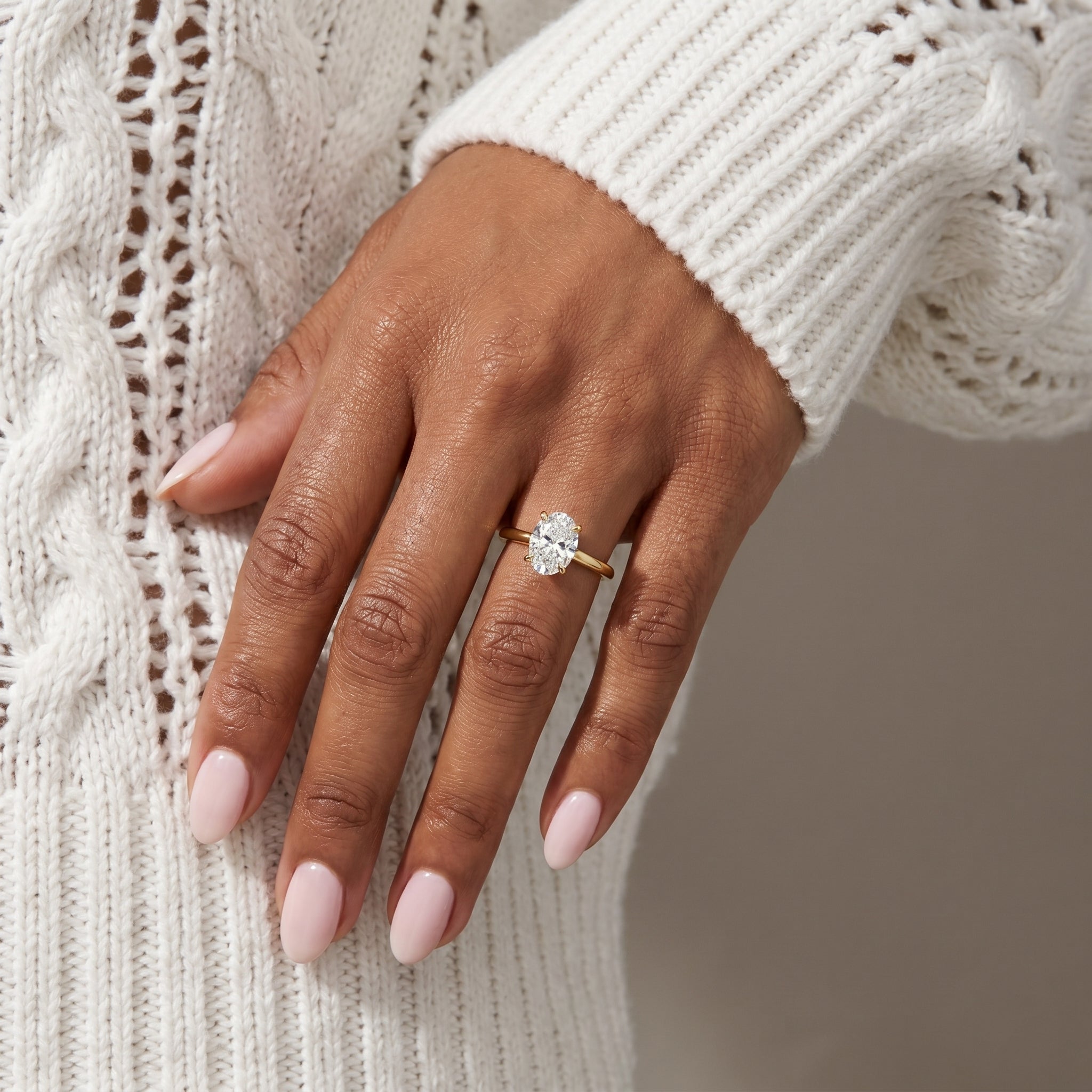 Oval moissanite solitaire ring with stacking bands on hand yellow gold jewelry styling

